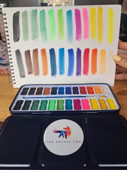 Children's and beginner's watercolour paint set by The Artful Fox. With 24 vibrant colours, in attractive tin with palette lid. Includes paintbrush! The perfect educational gift for the hobby artist in your life
